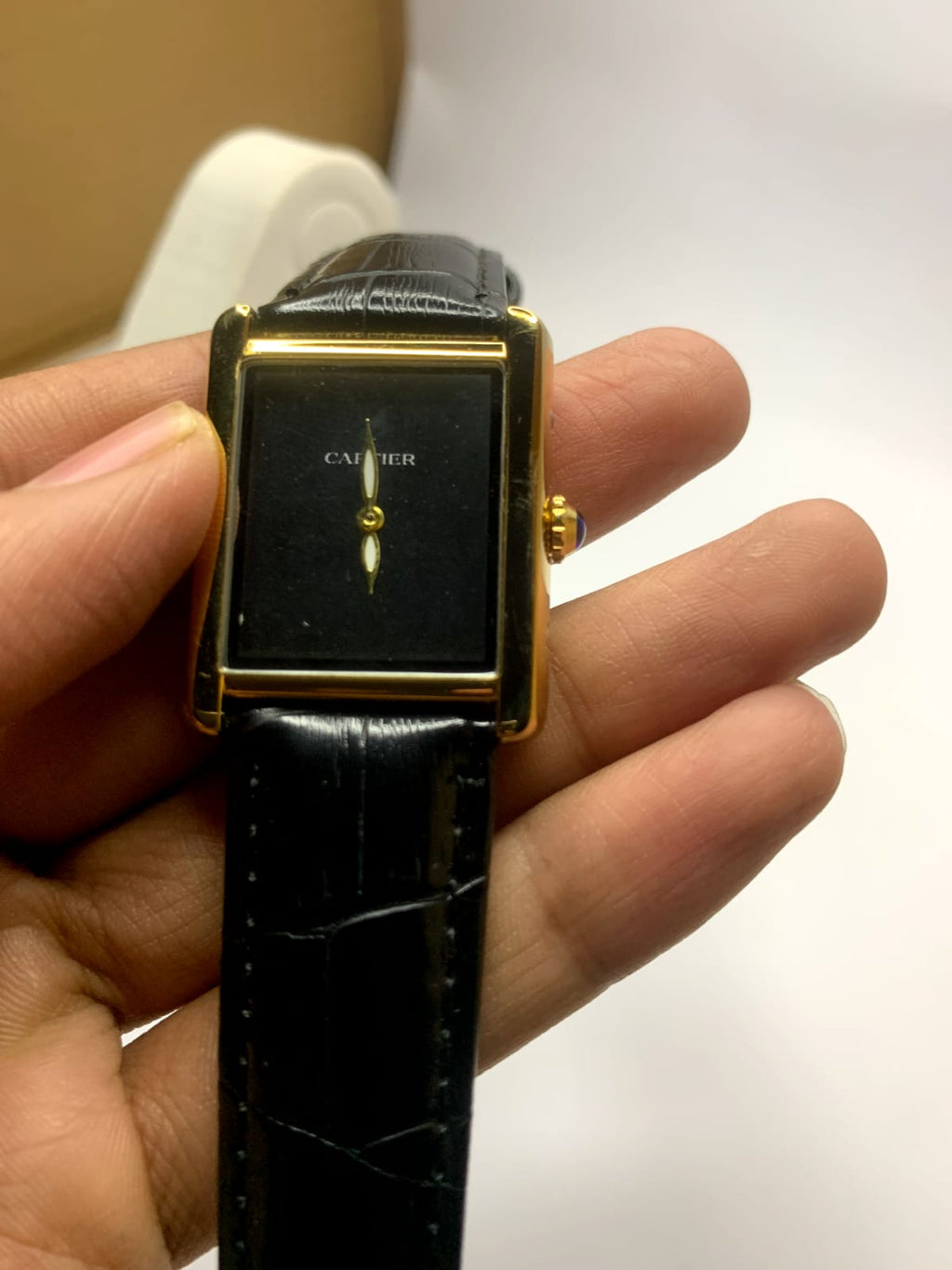 *Cartier Tank* watch featuring a rectangular steel case,