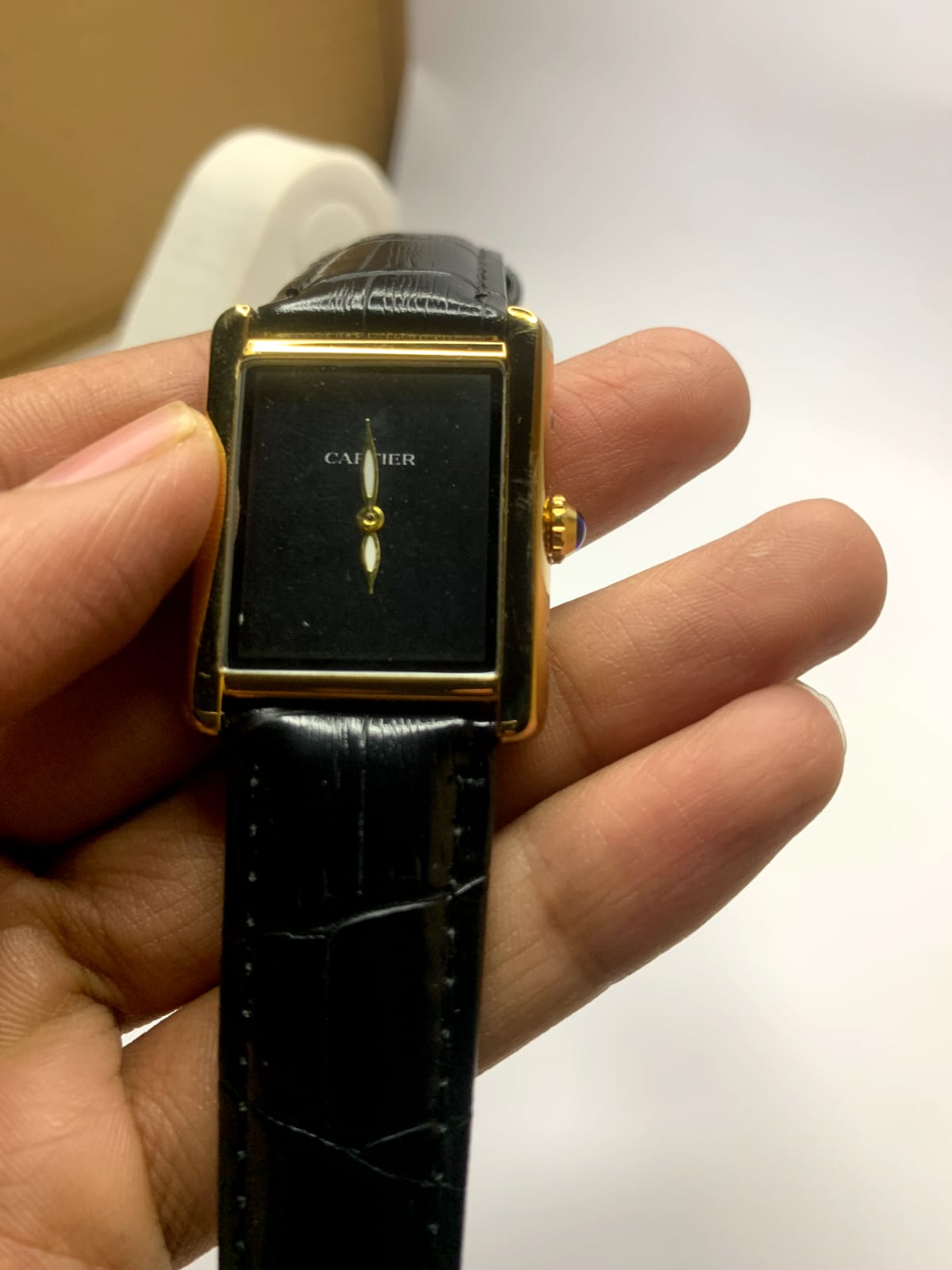 *Cartier Tank* watch featuring a rectangular steel case,