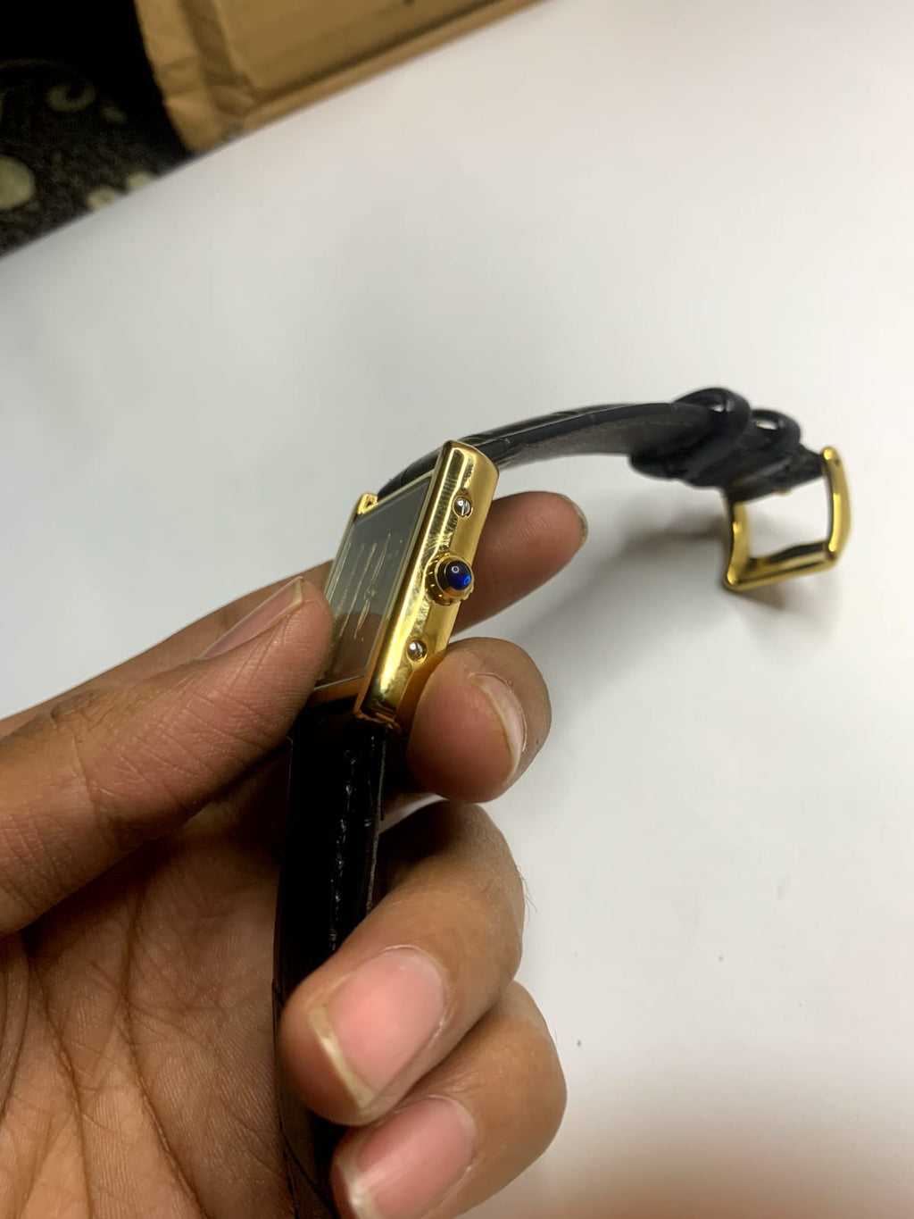 *Cartier Tank* watch featuring a rectangular steel case,