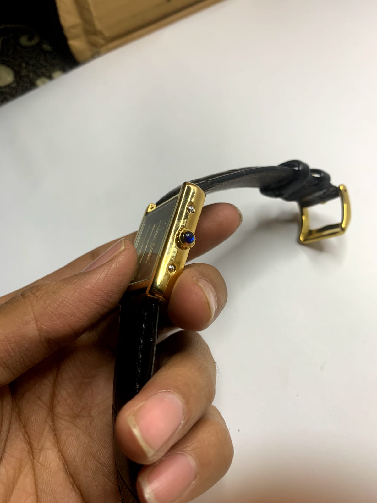 *Cartier Tank* watch featuring a rectangular steel case,